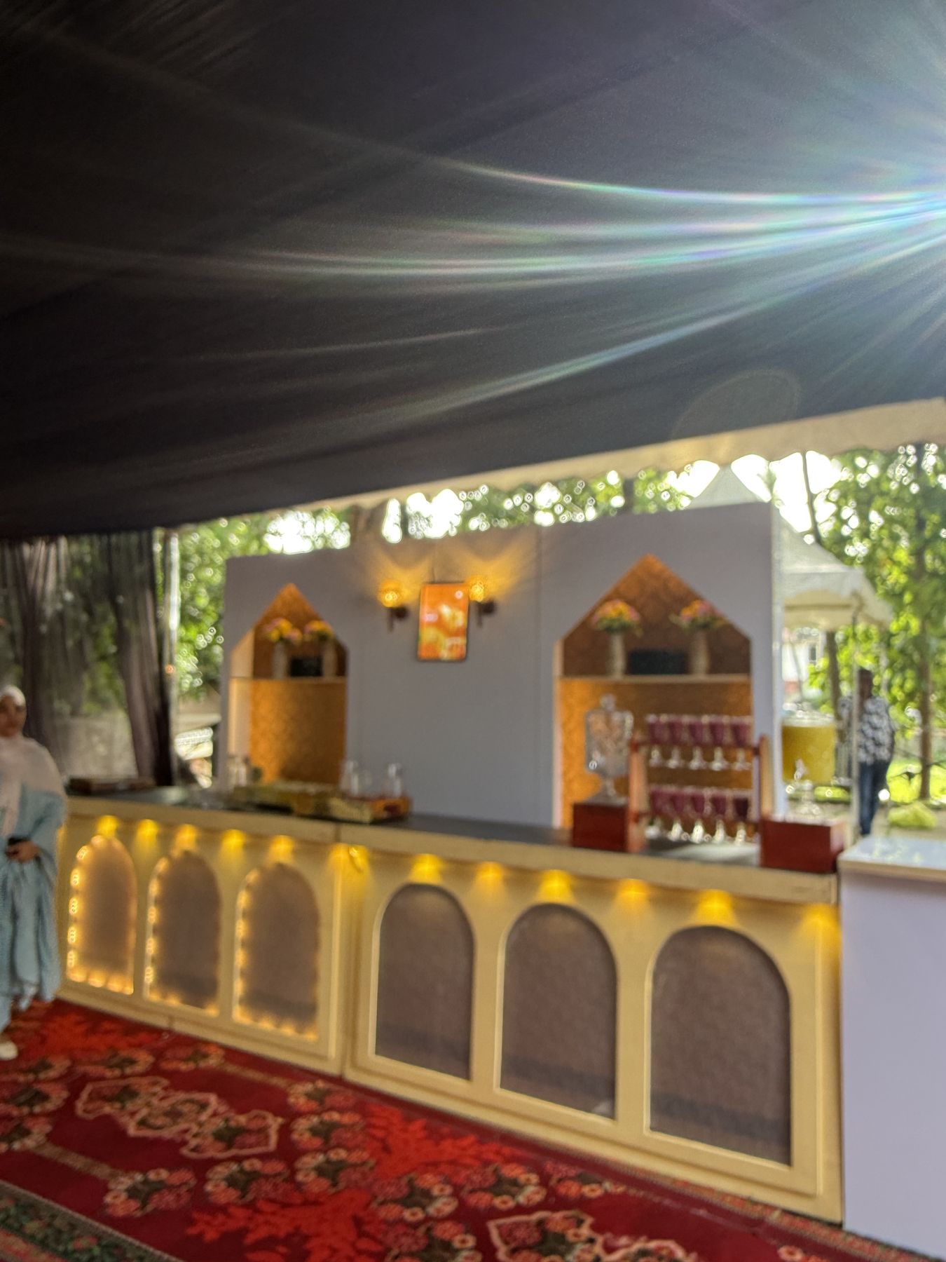 Long catering counter with illuminated arches on a red carpet